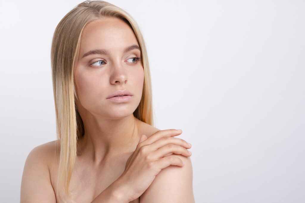 Woman with smooth skin looking to the side after erbium glass laser treatment.